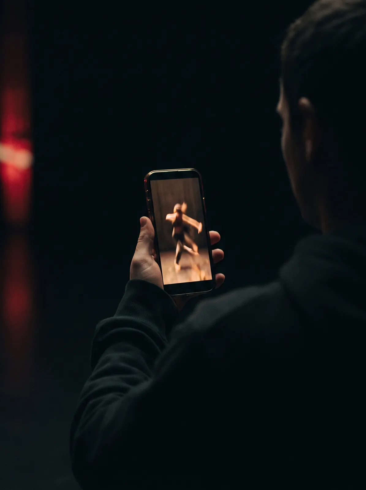 A phone in the dark playing a vertical video feed